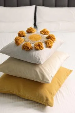 Stack of soft pillows and bedsheet on bed Stockfoto's