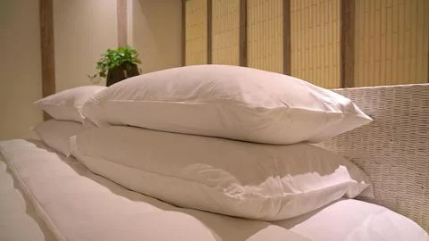 Stack of soft pink pillows on bed in cozy bedroom Stock Photos