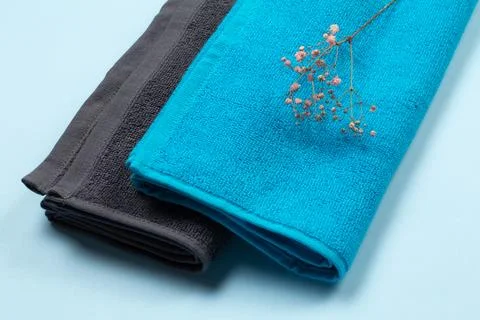 Stack of soft terry towels on blue background. Stock Photos