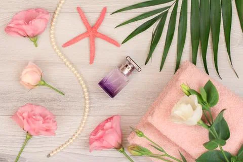 Stack of soft terry towels with flower and perfume on wooden boards Stock Photos