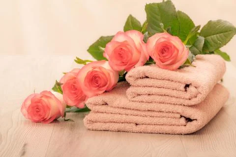 Stack of soft terry towels with flowers on wooden boards Stock Photos