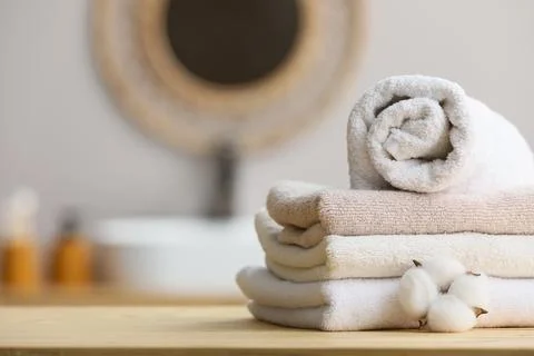 Stack of soft towels with cotton flower in bathroom Stock Photos