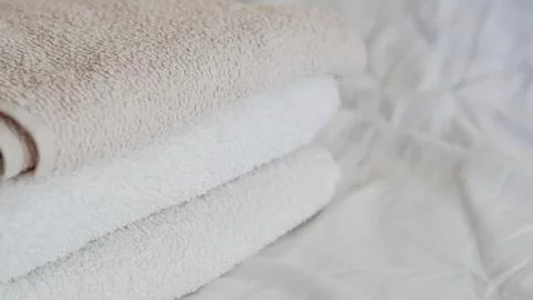 Stack of soft towels in neutral colors on a light fabric background Stock Photos