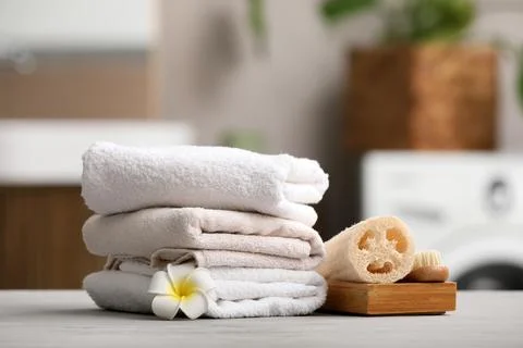 Stack of soft towels with spa accessories on table Stock Photos
