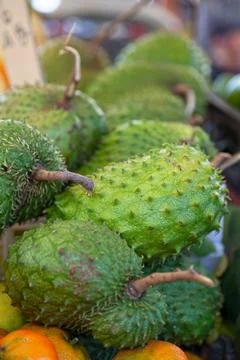 Stack of soursops on a market stall Stock Photos