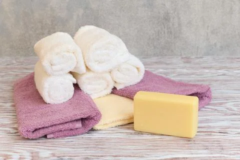 Stack of spa terry towel and soap bar on wooden table Stock Photos