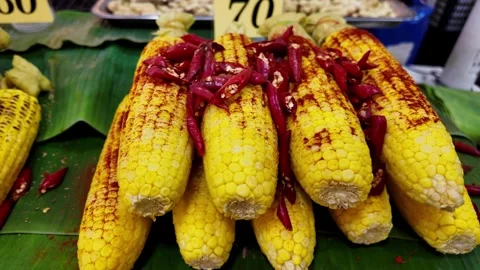 Stack of Spicy Grilled Corn Cobs with Red Chili Peppers at Thai Market Stock Footage 335998808