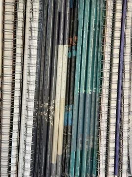 Stack of spiral-bound notebooks with various colored covers in a horizontal.. Фото