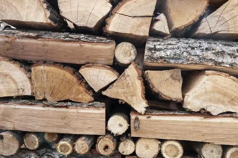 Stack of split firewood logs arranged for storage. Natural wooden texture Stock Photos