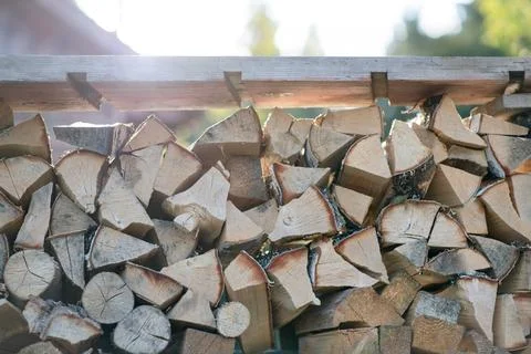 Stack of split firewood neatly stored on a wooden rack outdoors Stock Photos