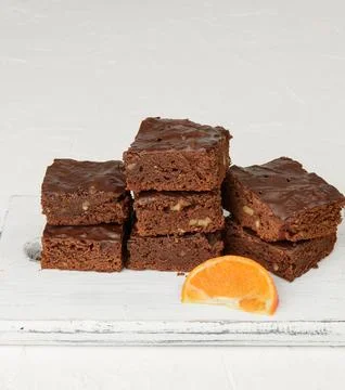 Stack of square baked slices of brownie chocolate cake with walnuts Stock Photos