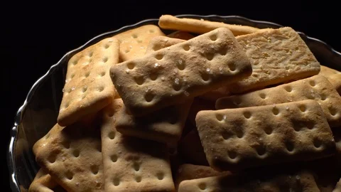 Stack of square crackers on a black background in rotation. Crackers spin. Video stock 99945405