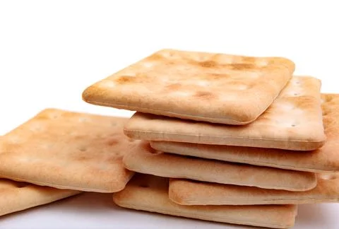A stack of square crisp crackers on a white background. Stock Photos
