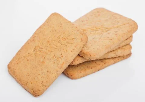 Stack of square organic crispy wheat and five grain salty crackers on white Stock Photos