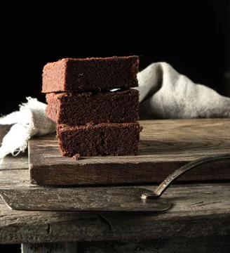 Stack of square pieces of baked brown brownie pie on a wooden  board 스톡 사진
