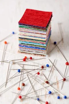 Stack of square pieces of colorful fabrics and heap of multicolor ball head.. Fotos Stock