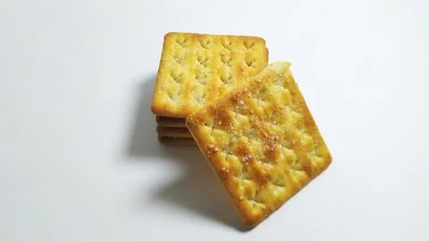 Stack of square salty crackers on white background. Stock Photos