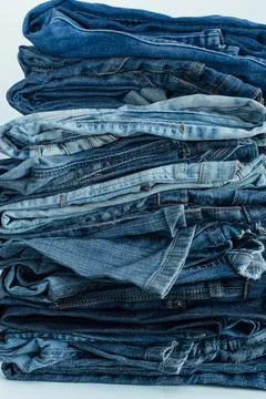 Stack of a stack of old jeans various shades of blue jeans. Denim jeans textu Stock Photos