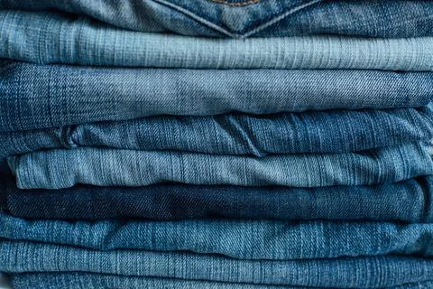 Stack of a stack of old jeans various shades of blue jeans. Denim jeans textu Stock Photos