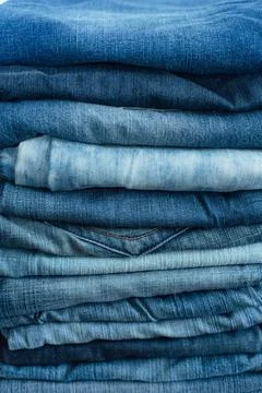 Stack of a stack of old jeans various shades of blue jeans. Denim jeans textu Stock Photos