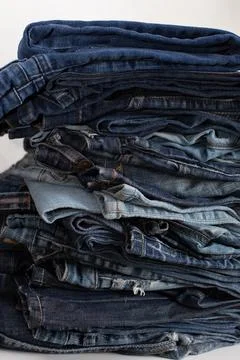 Stack of a stack of old jeans various shades of blue jeans. Denim jeans textu Stock Photos