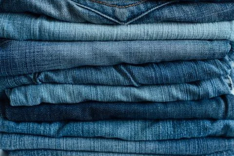 Stack of a stack of old jeans various shades of blue jeans. Denim jeans tex.. Stock Photos