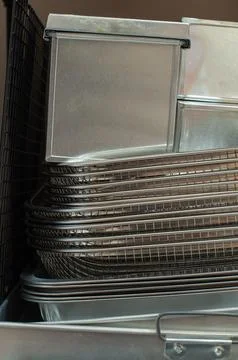 Stack Of Stainless Steel Baking Trays And Wire Baskets On Kitchen Rack Stock Photos