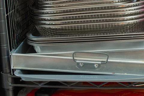 Stack Of Stainless Steel Baking Trays And Wire Baskets On Kitchen Rack Stock Photos