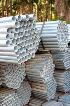 Stack of stainless steel round pipes. Metal pipes background Stock Photos