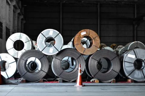 Stack of steel coil in storage warehouse. Steel coils handling equipment. Stock Photos