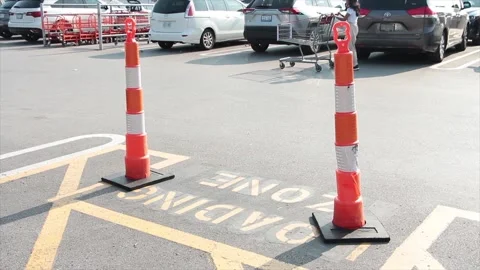 Stack sticks tall orange white black pylons on top of loading zone writing Stock Footage 251361591