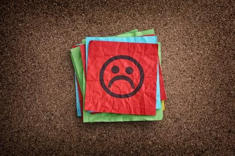 A stack of sticky notes with sad faces on them Stock Photos