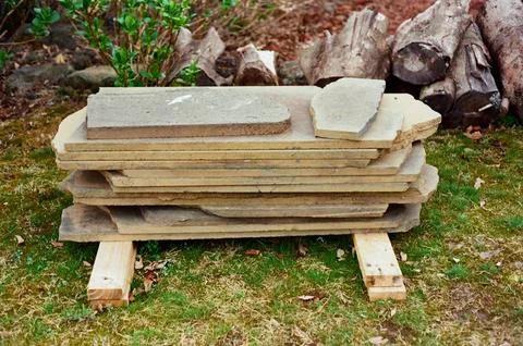 Stack of Stone Slabs on Wooden Supports in Yard Stock Photos