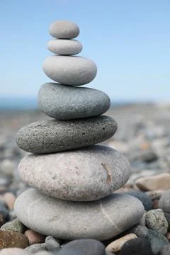 Stack of stones on beach against blurred background, closeup Foto stock