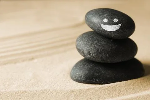 Stack of stones with drawn happy face on sand, space for text. Be in harmony  스톡 사진