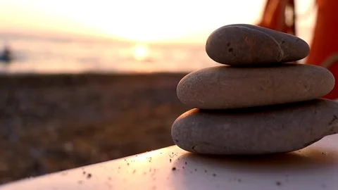 A stack of stones by the sea at sunset Stock Footage 217538778