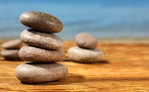 Stack of stones on wooden table against seascape, space for text. Zen concept 스톡 사진