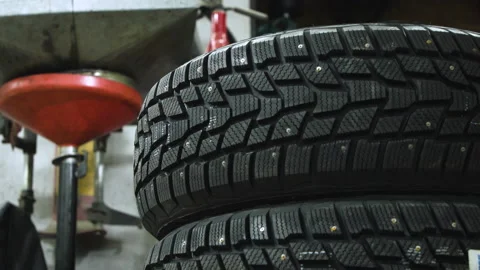 A stack of studded snow tires inside an auto mechanic's garage Stock Footage 131535482
