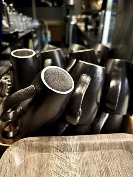 A stack of stylish, matte black ceramic mugs Stock Photos