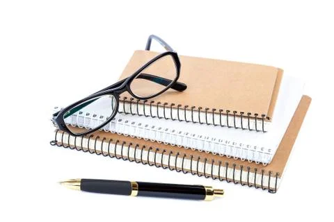 Stack stylish notebook, pen and glasses. Stock Photos