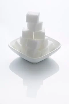 A stack of sugar cubes in a bowl Stock Photos