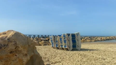 Stack of sun loungers on the sandy beach Video stock 154377512