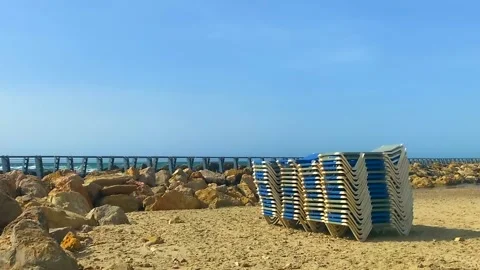 Stack of sun loungers on the sandy beach Stock Footage 154377533