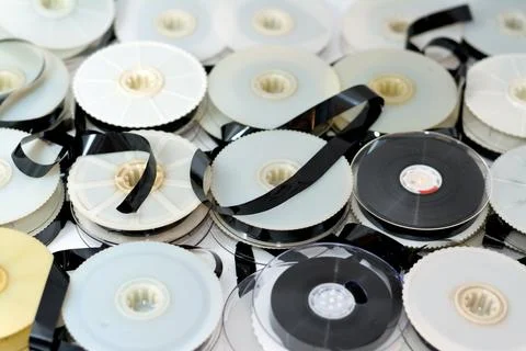 Stack of supply and take up reels with ribbon of VHS video cassette tapes use Stock Photos