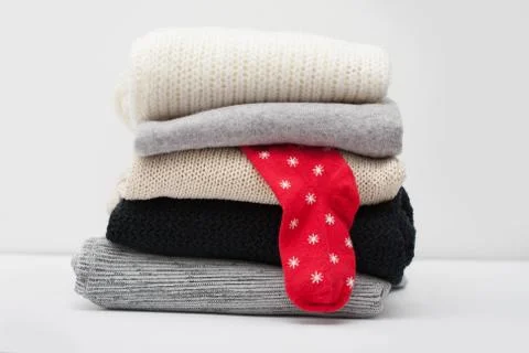 Stack of sweaters with one sock Stock Photos