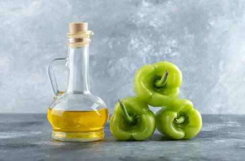 Stack of sweet peppers with bottle of oil 스톡 사진