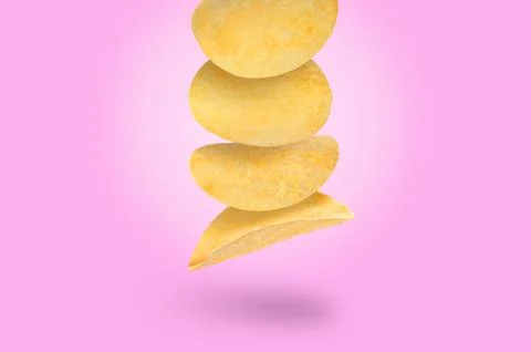 Stack of tasty potato chips falling on light violet background Stock Photos