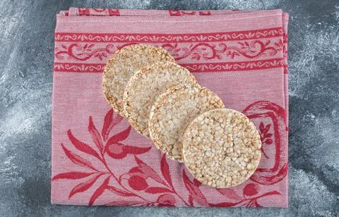 Stack of tasty round crispbread on red cloth Foto stock