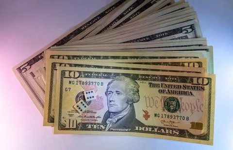 A stack of ten dollar bills with dice on top for a game night theme Stock Photos