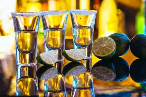 Stack of tequila with salt close up on blurred background Stock Photos